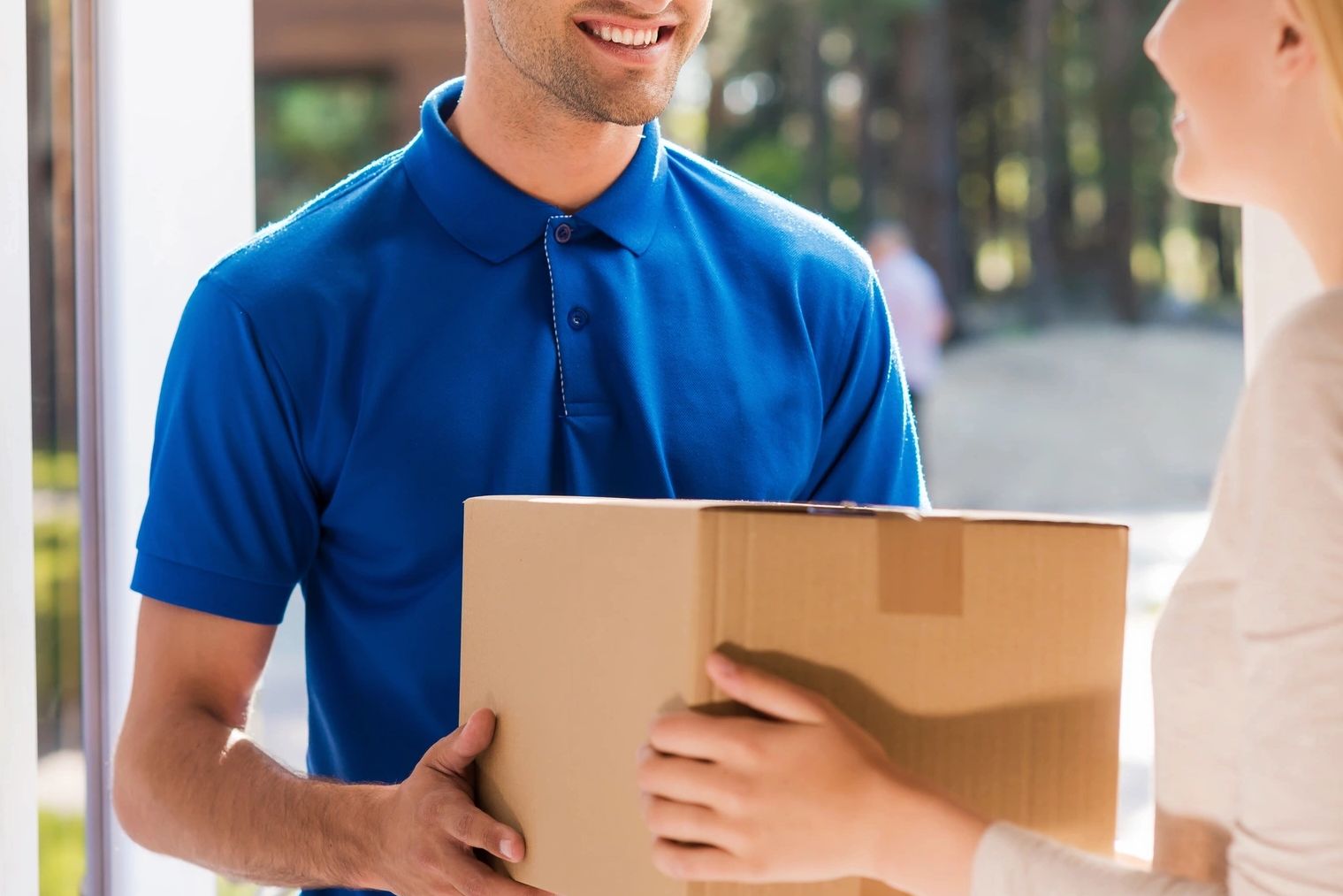 A delivery guy handing a package to a woman